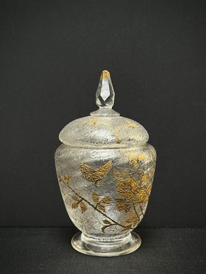 un bocal en verre orné d'un motif de feuilles d'or