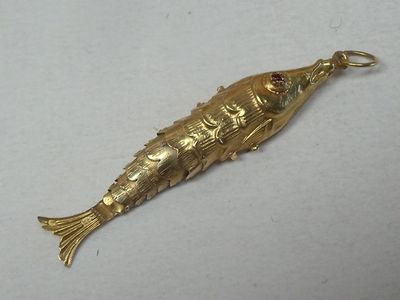 a gold fish shaped object on a white surface
