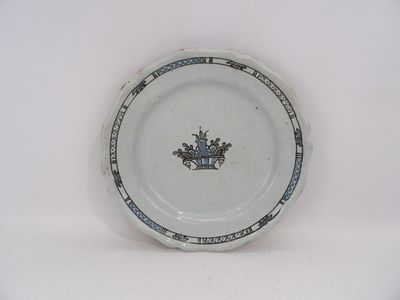 une assiette blanche avec une bordure bleue et une couronne dessinée dessus