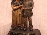 une statue représentant un homme et une femme debout l'un à côté de l'autre