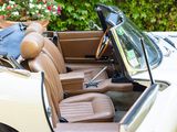 a white car with tan leather seats and a blue bag in the back seat