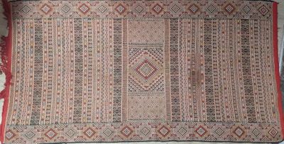 une photo d'un tapis posé sur un lit, avec une bordure rouge
