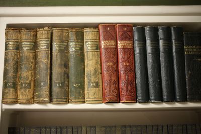 de nombreux livres anciens rangés sur une étagère d'une bibliothèque