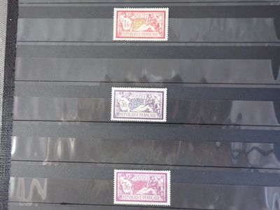 cinq timbres différents sur une feuille de papier noir