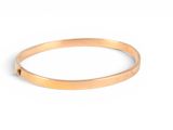 a close up of a gold bracelet on a white background