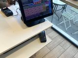 a person standing at a table with a laptop and a cell phone