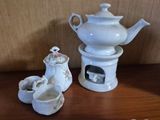 a white tea pot and two cups sitting on a table