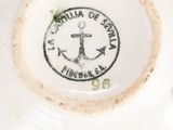 a close up of a white plate with an anchor on it