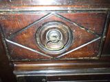 a close up of a door handle on a wooden cabinet