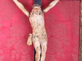 a statue of jesus on a cross on a red wall