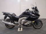 bmw motorcycle parked in a garage with a checkered floor