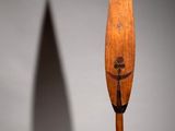 an image of a wooden paddle with a shadow of a person on it