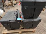deux boîtes noires posées sur une palette dans un entrepôt