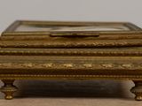 a small gold box with a mirror on top of it