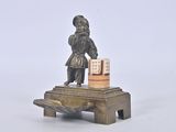 a small statue of a man with a box on a table