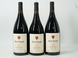 three bottles of wine are lined up on a white surface