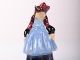 a small figurine of a woman in a blue dress