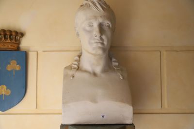 un buste de femme coiffée d'une couronne, posé au-dessus d'une horloge