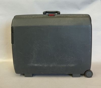 une valise noire posée sur une surface blanche