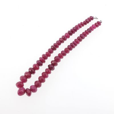 gros plan d'un collier de perles rouges sur fond blanc