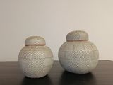 deux vases blancs posés l'un à côté de l'autre sur une table