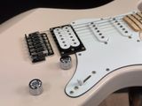 a white electric guitar that is sitting on a table