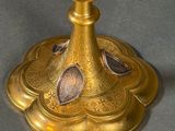 a gold candle holder with a candle on top of it