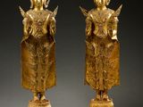 deux statues en or représentant une femme et un homme debout sur un socle