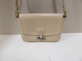 beige leather purse with a metal clasp on a white table
