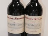 two bottles of wine sitting on top of a table next to each other