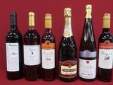 several bottles of wine are lined up on a red table