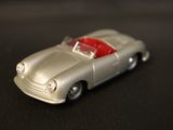a silver toy car with a red top on a black surface