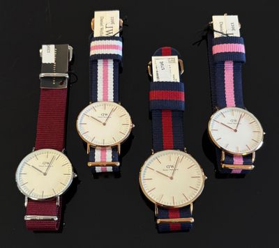 Quatre modèles de montres différents sont présentés sur un fond noir
