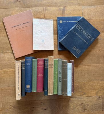 several books are stacked on a wooden table next to each other