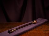 a glass of wine and a wooden stick on a table