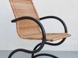 une image représentant une chaise aux pieds en métal noir et à l'assise en osier