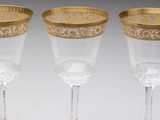 three glass goblets with gold rims on a white background