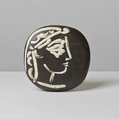 sculpture en céramique en noir et blanc représentant le visage d'une femme sur un fond blanc