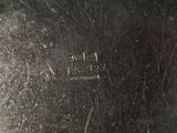 a close up of a silver vase with a handle