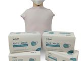 trois boîtes de masques faciaux et une tête de mannequin sur fond blanc