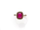 a close up of a ring with a pink stone surrounded by diamonds