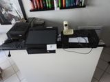 un bureau sur lequel se trouvent un ordinateur portable, un téléphone et une imprimante
