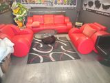 a living room with red leather couches and a coffee table