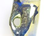 a blue and yellow vase with a fish inside of it