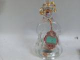 a small glass bottle with a small clock inside of it
