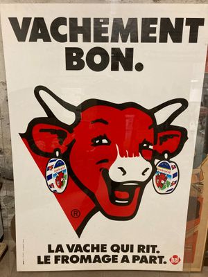 affiche représentant une vache rouge au visage souriant devant un mur de briques