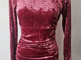 La robe est en velours froissé et possède des manches longues.