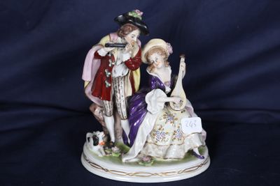une figurine représentant un homme et une femme assis sur un banc