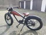 une moto noire et rouge garée devant un immeuble