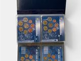 four different types of coins in a black box on a white surface